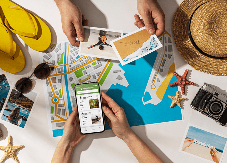 Travel photographs, a map and a phone spread across a table